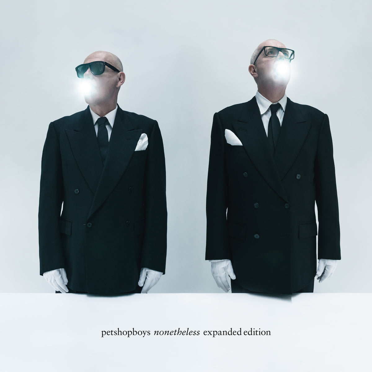 Two suited figures with blurred faces against a white background.