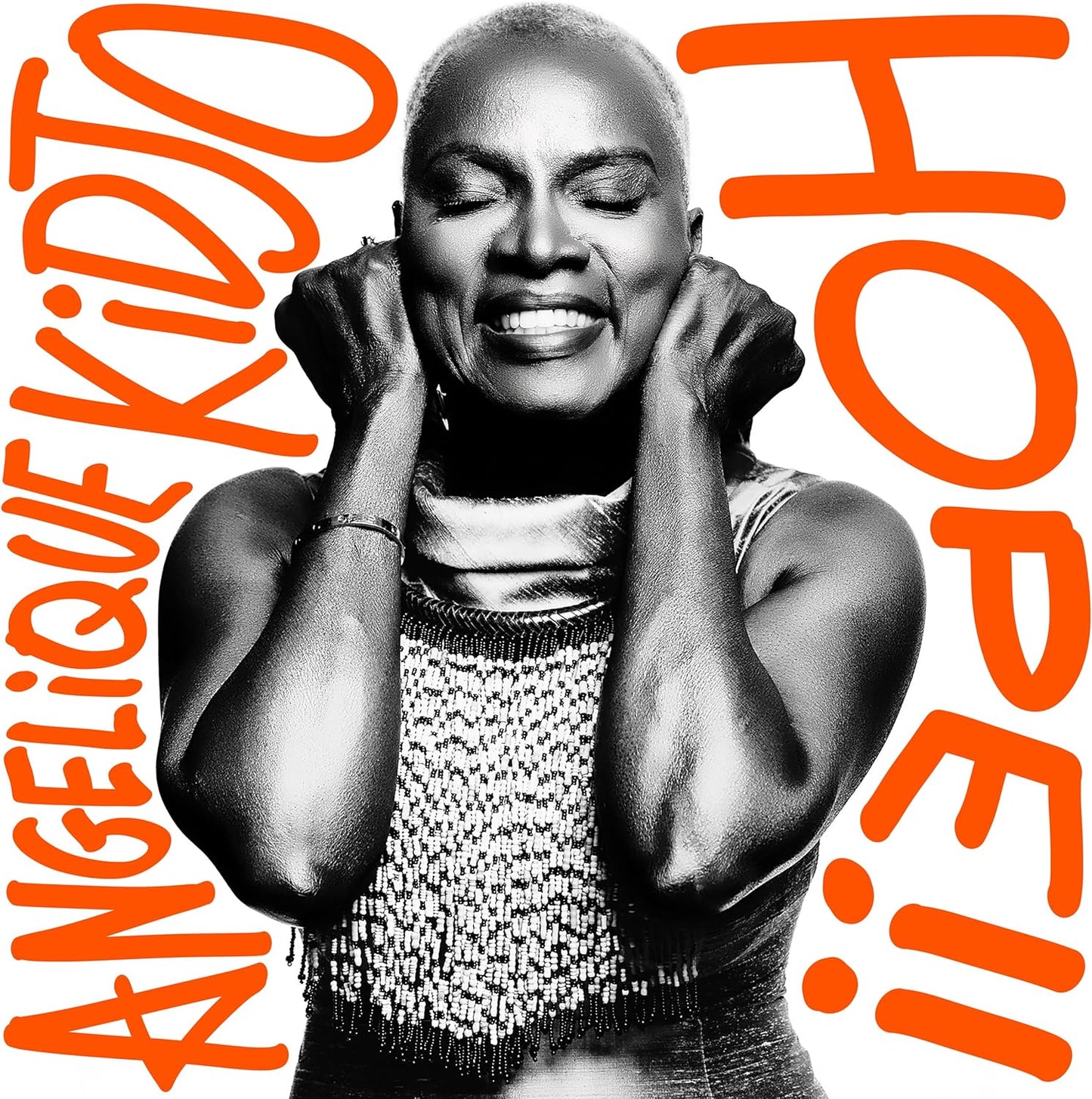 Angelique Kidjo album cover, black and white portrait with bold red text.