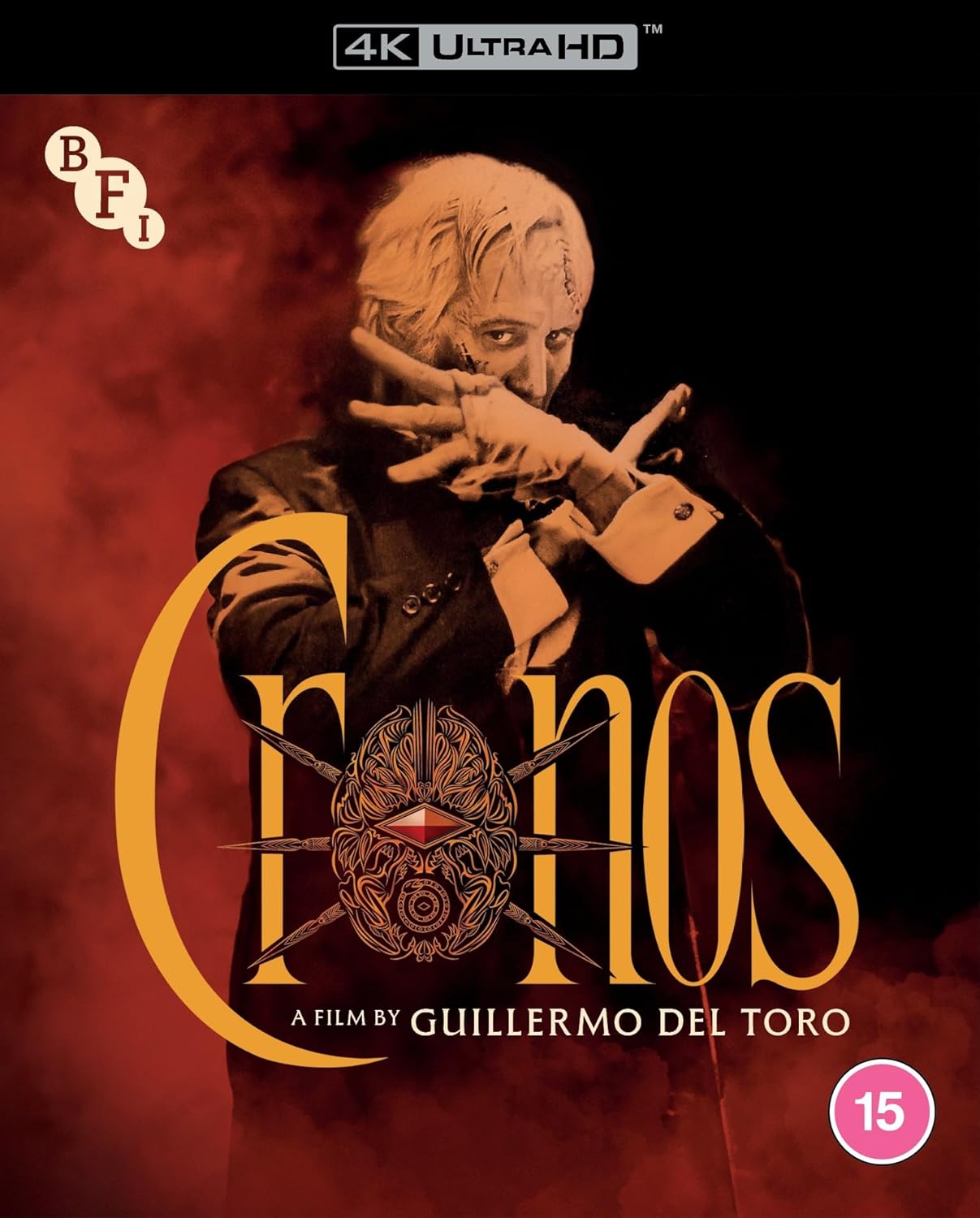 Blu-ray cover art for Cronos featuring a man in a suit against red smoke.