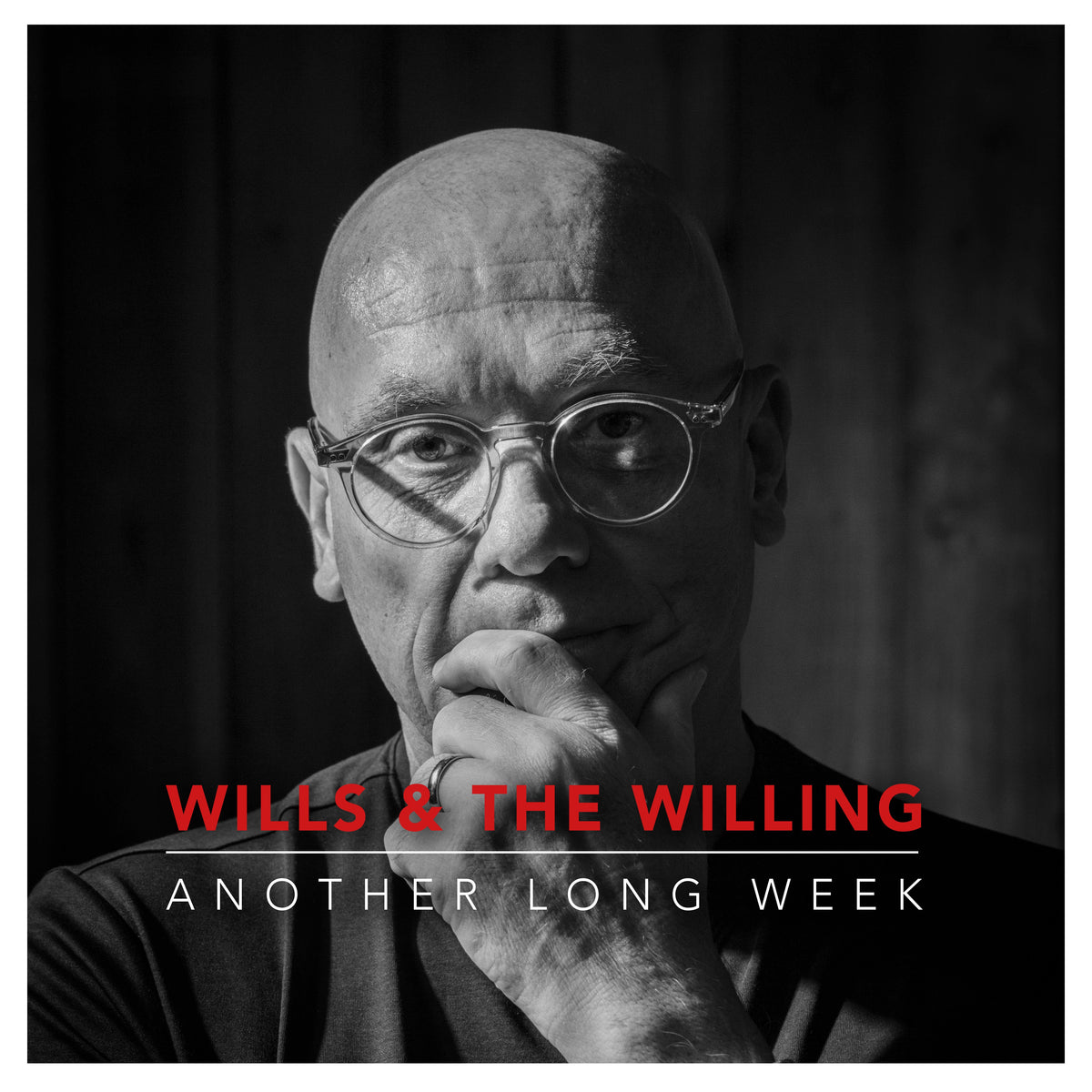 Black and white portrait of a man with glasses, album cover art.