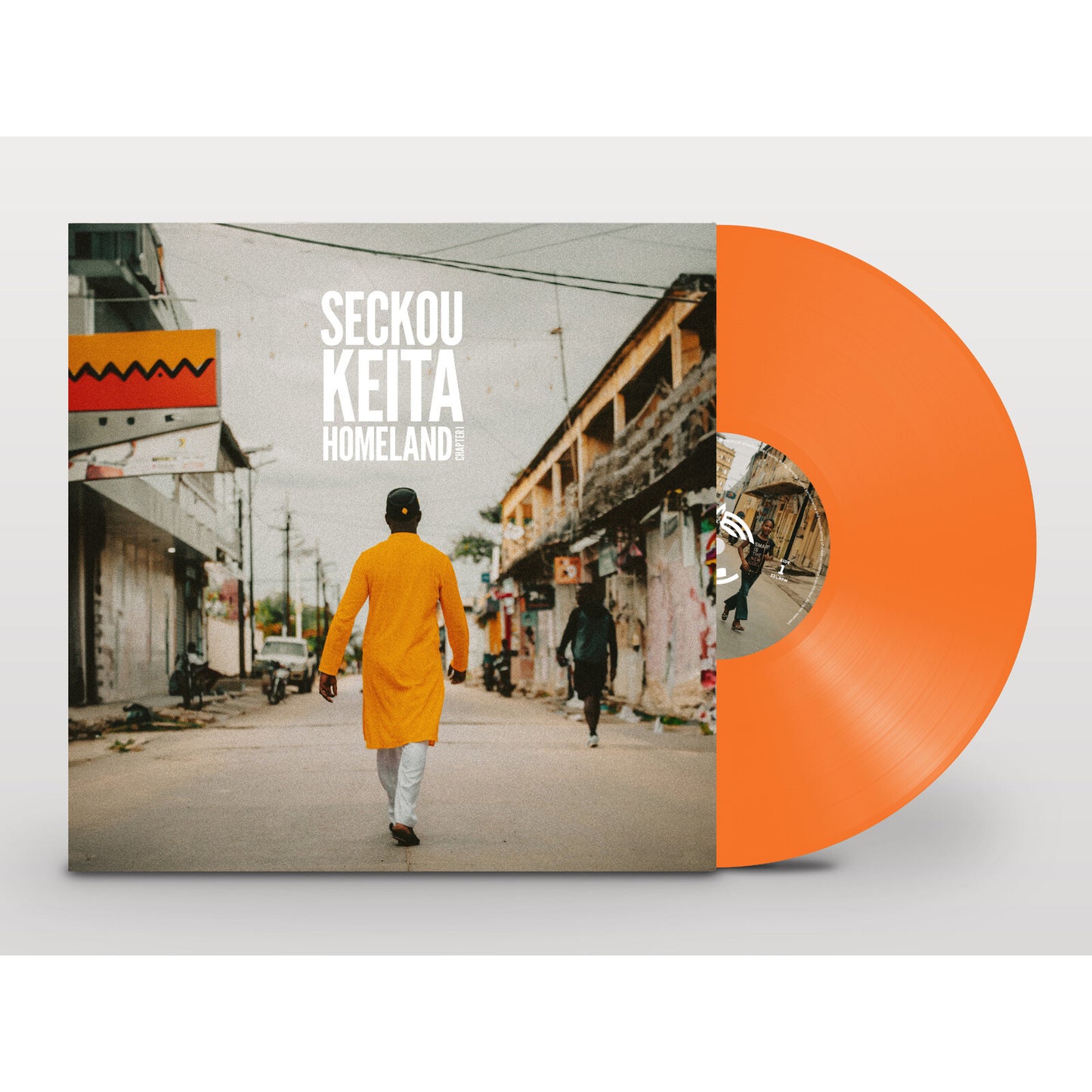 Orange vinyl record with album art of a man walking away from buildings.