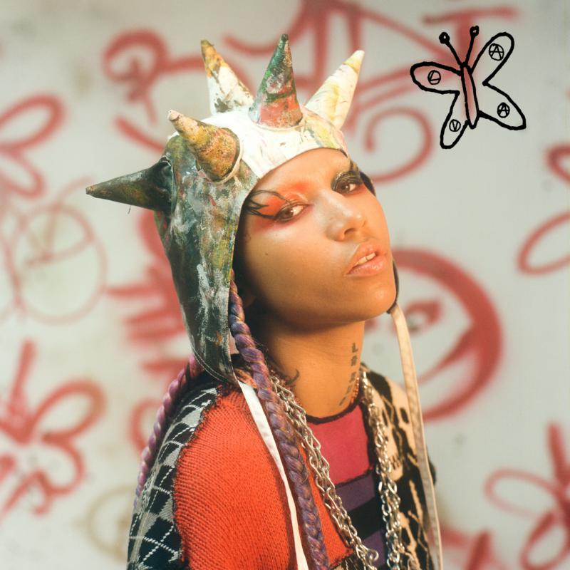 Lava La Rue portrait with colorful makeup, crown, and butterfly doodle.