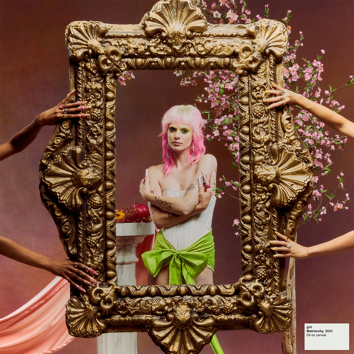 Woman framed by ornate gold, with hands and blossoming branches.