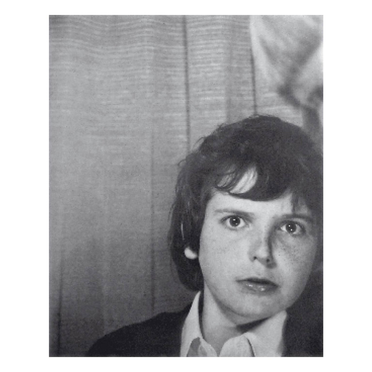 Black and white portrait of a young person with dark, curly hair.