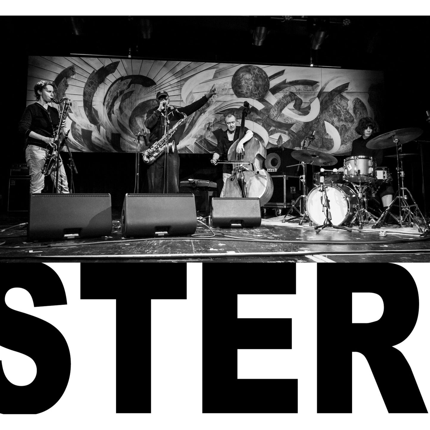 Black and white photo of four musicians performing on stage.