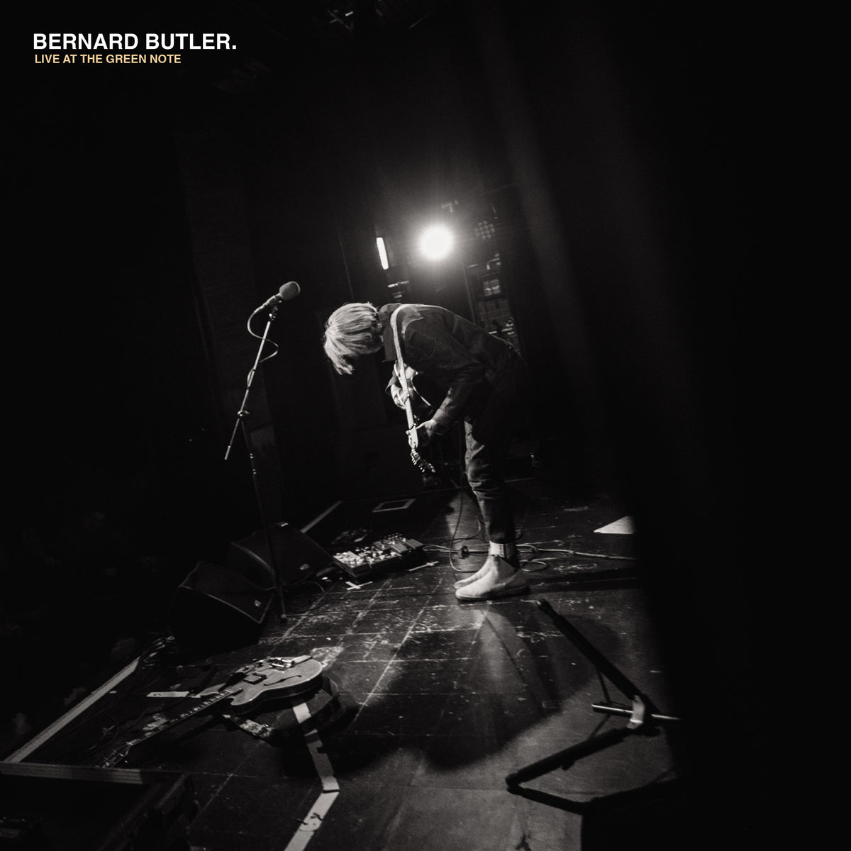 Bernard Butler playing guitar onstage in black and white.
