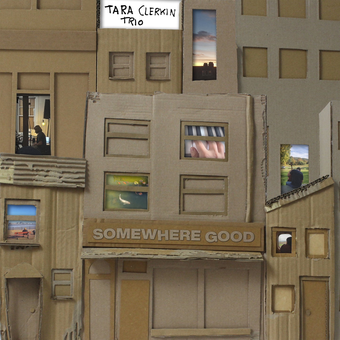Cardboard building facade with window scenes, album title "Somewhere Good".