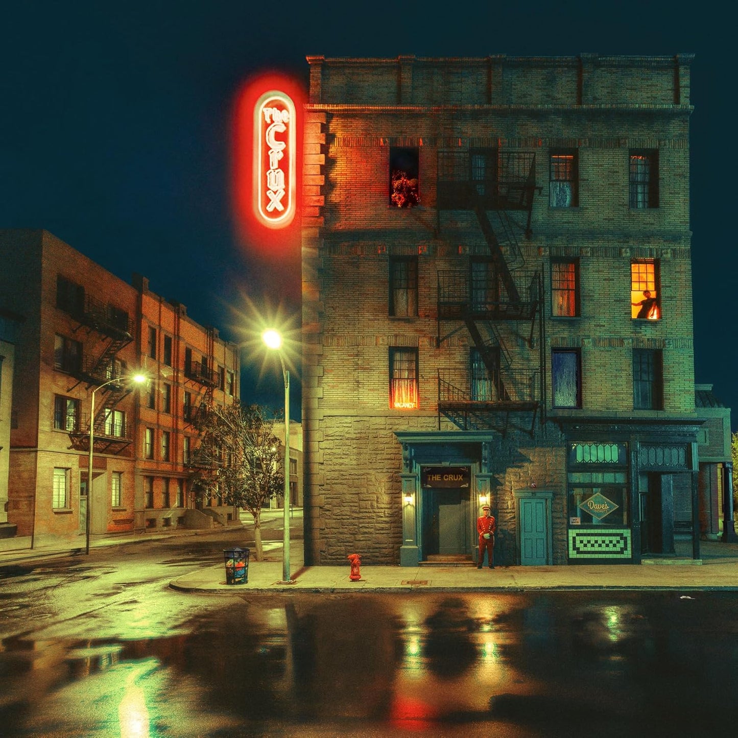A night street scene featuring a brick building with a glowing red neon sign.