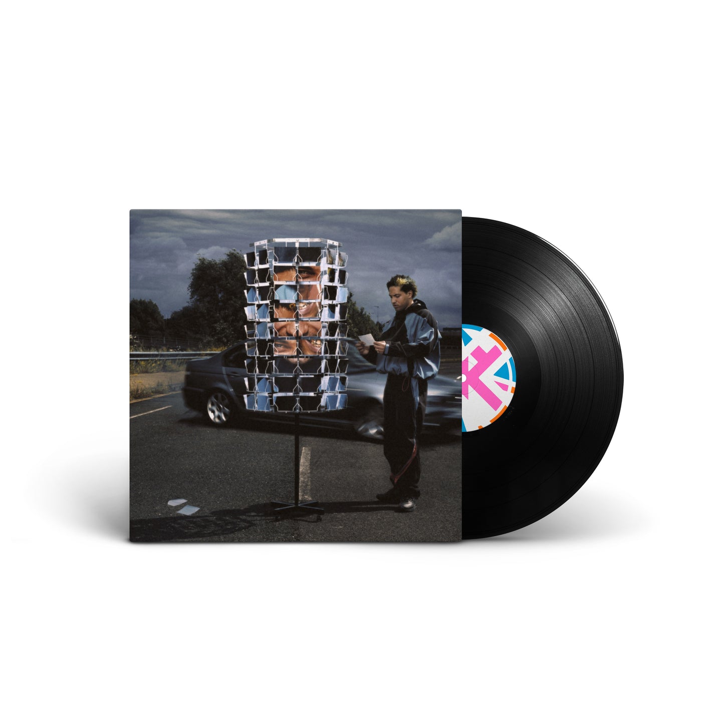 Vinyl record and album cover featuring a man standing by a spinning postcard rack.