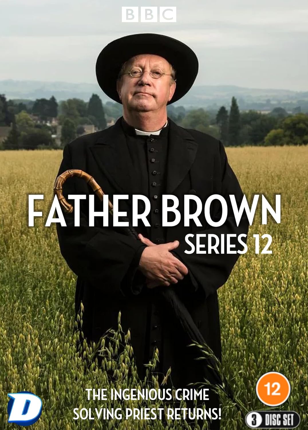 Father Brown wearing a black hat and cassock standing in a grassy field.