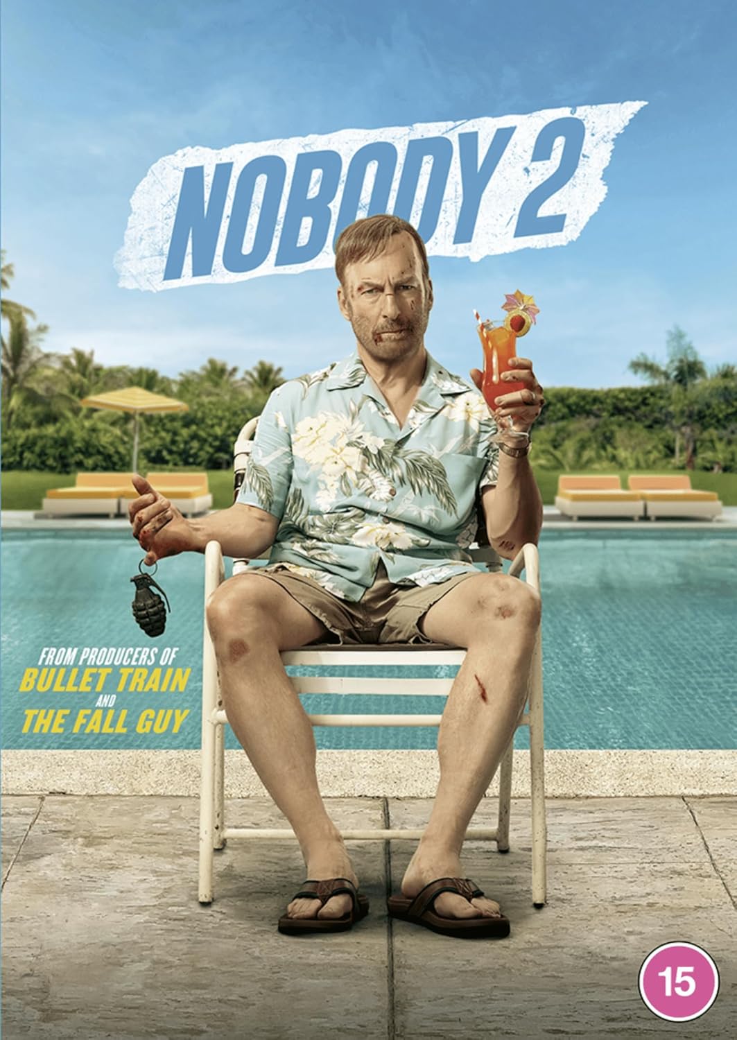 A battered man in a floral shirt sits by a pool holding a cocktail grenade.