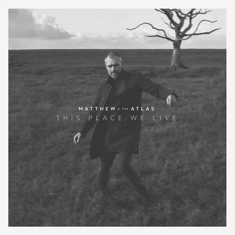 Black and white album cover featuring a man in a field under a bare tree.