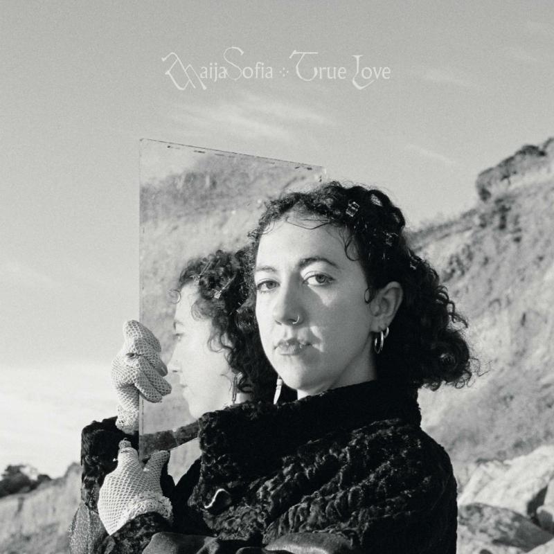 Black and white portrait of a woman holding a reflective surface.
