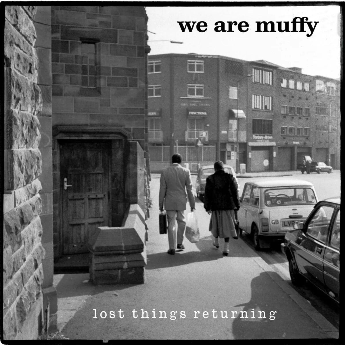 Black and white CD cover with people walking near buildings and a car.