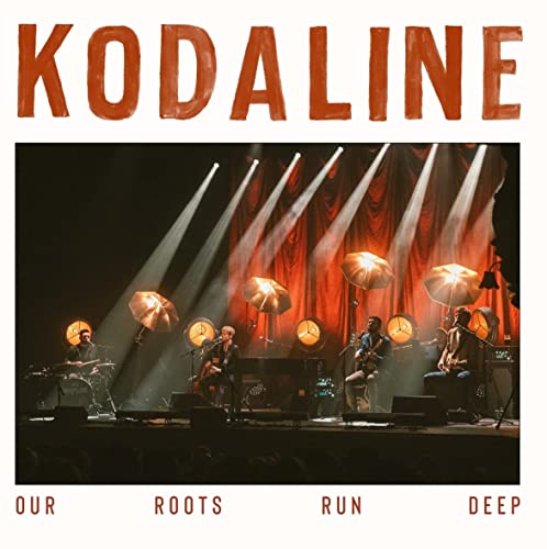 Kodaline band performing on stage with illuminated umbrellas, album cover.