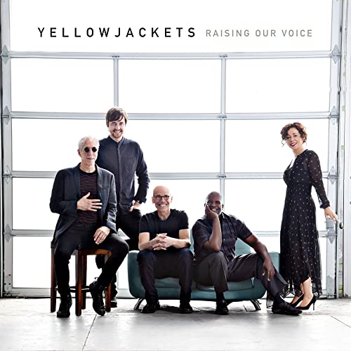 Yellowjackets band members posing in front of an open garage door.