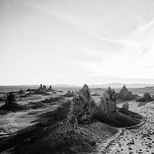Black and white landscape of rocky formations under a cloudy sky.