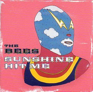 CD cover: wrestler mask with clouds and lightning on pink background.