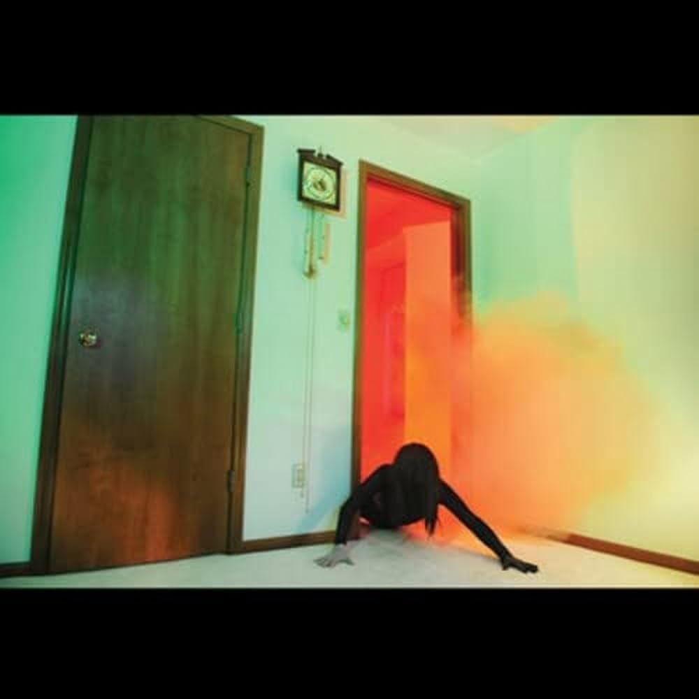 Person contorted near a brightly lit doorway in a pale room.