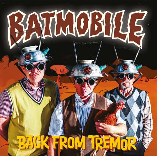 Three men in helmets and goggles with a chicken, album cover.
