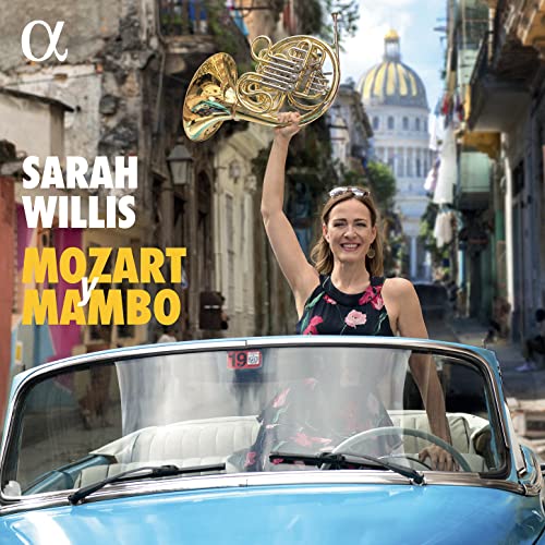 Sarah Willis holding a French horn in front of a Cuban street.