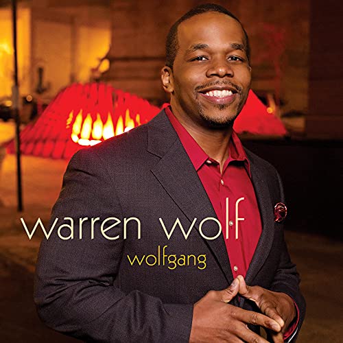 Warren Wolf portrait on CD cover, wearing a suit and smiling.