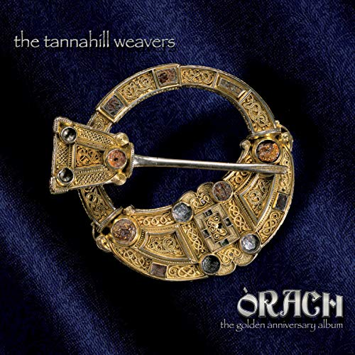 An ornate gold Celtic penannular brooch on a dark blue fabric background.