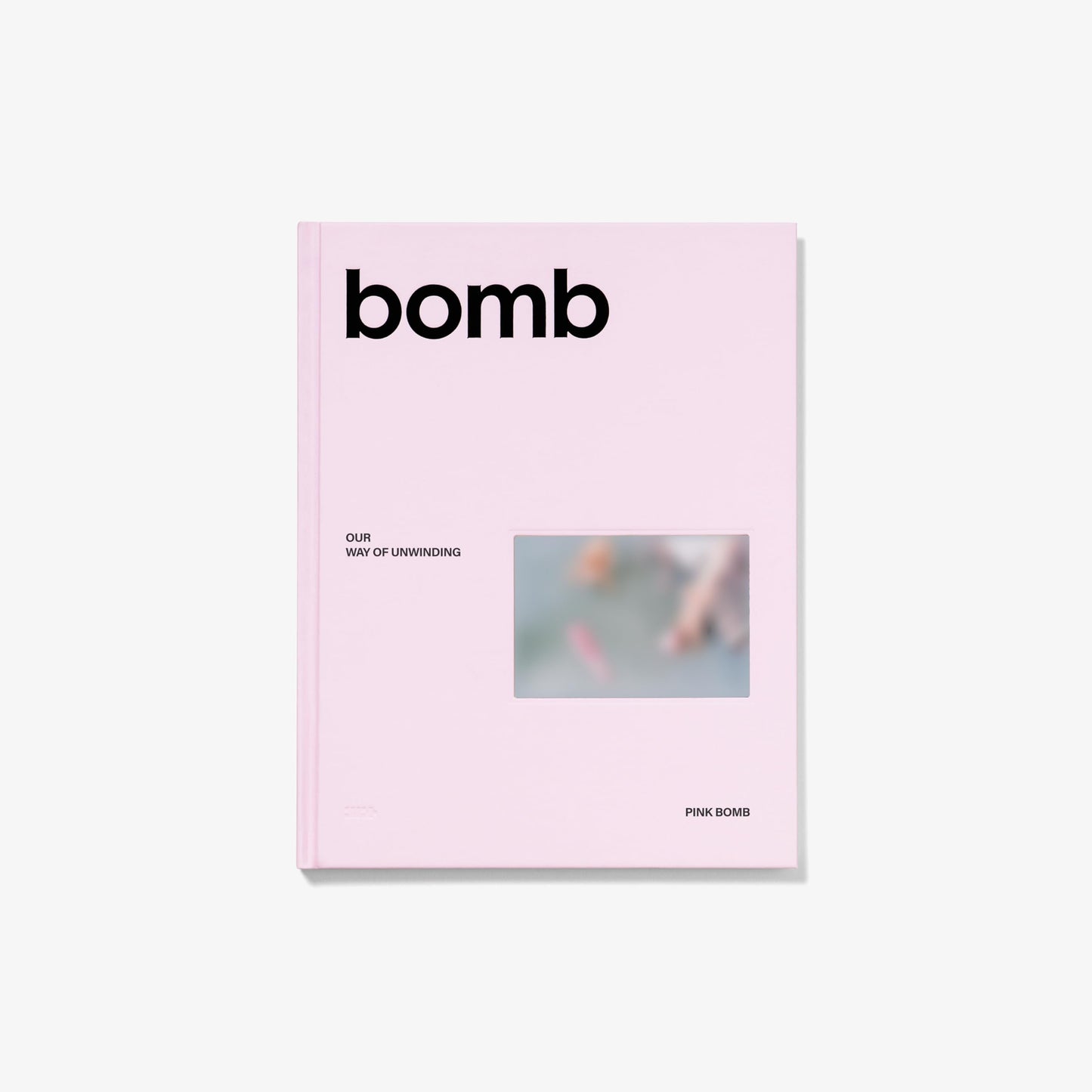 Pink CD case for Illit’s “bomb” album with blurred image.