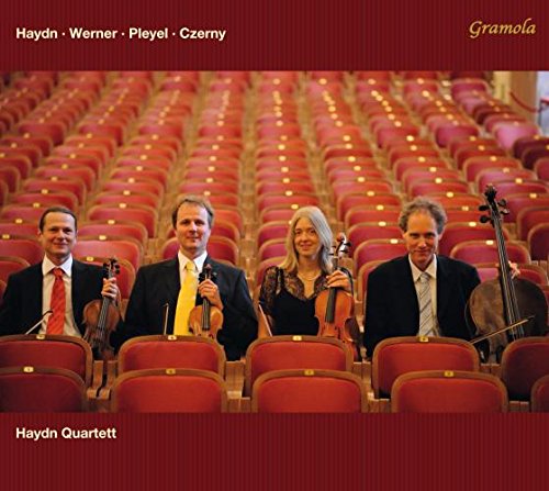 Haydn Quartett musicians seated on a stage before red theatre seats.