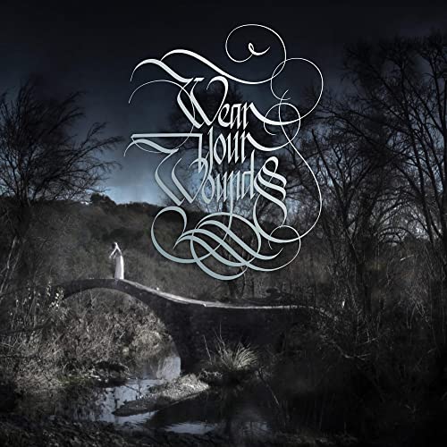 Album cover with ornate script over a dark, misty landscape and bridge.
