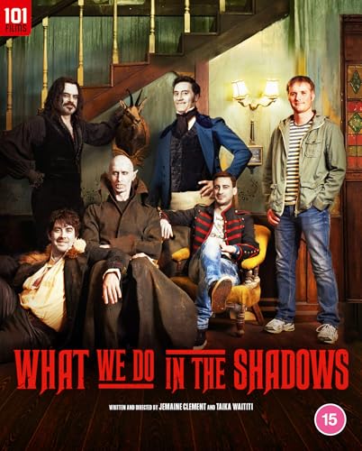 Cast of What We Do in the Shadows posing inside a dimly lit room.