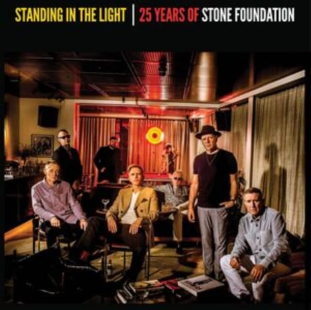 Stone Foundation band members posed in a dimly lit, vintage-style room.