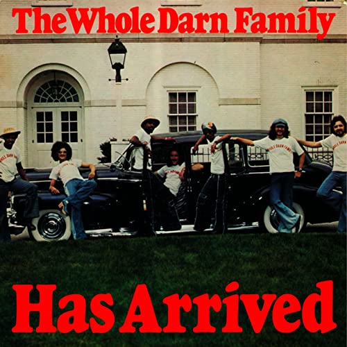 Album cover featuring a family posing with a classic car in front of a house.