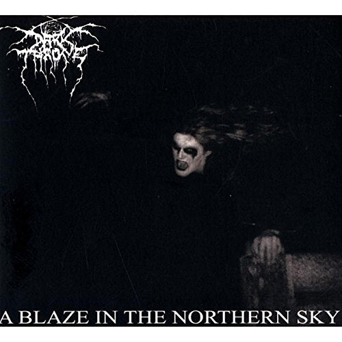 Darkthrone album cover: a dark, blurry figure in a snowy landscape.