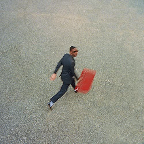 Blurred image of a man in a suit running with a red case.
