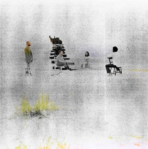 Four people sit or stand on chairs in a grainy, surreal, pale landscape.