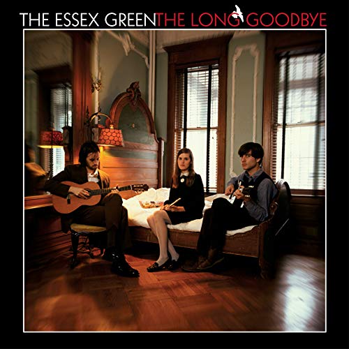 Three musicians with instruments sit in a vintage-style room.