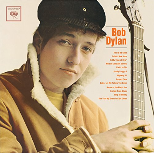 Bob Dylan wearing a cap and jacket, holding a guitar on his album cover.