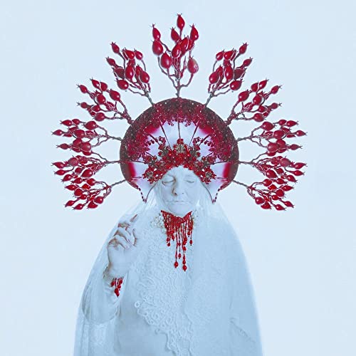 Woman with elaborate red headpiece and white lace clothing.