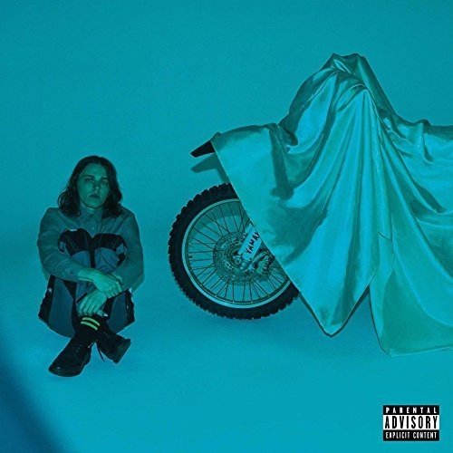 CD cover: man beside a motorcycle covered with a white sheet.