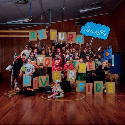 Large group of people and animals holding letters spelling “Return to the Riverside”.