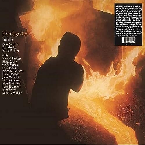 Silhouette of a person standing before a large, bright, flowing stream of molten metal.