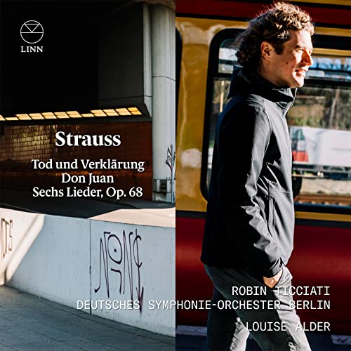 CD cover featuring a man in a black jacket beside a yellow train.