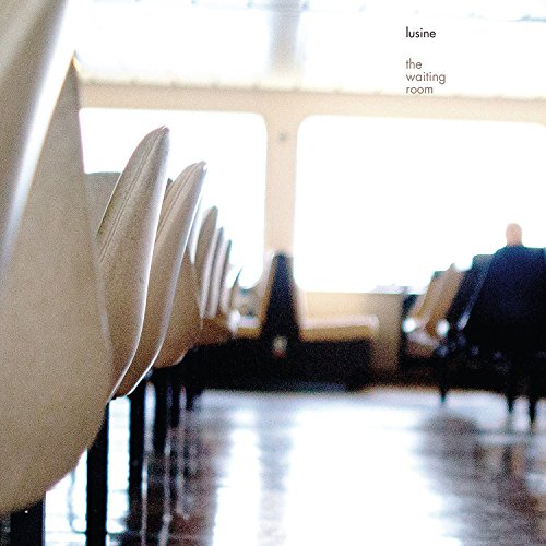 Rows of empty chairs in a brightly lit, sterile waiting room.