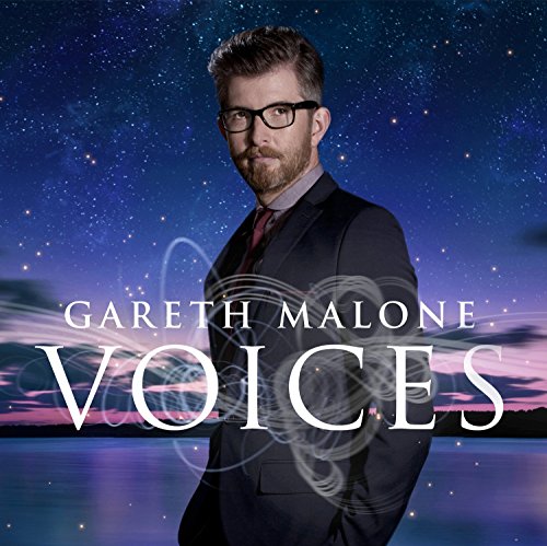 Gareth Malone in a suit against a starry night sky and lake background.