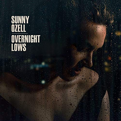 Album cover for Ozell’s “Overnight Lows” featuring a person looking out a wet window.