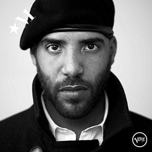 Black and white portrait of Miles Mosley wearing a beret and coat.