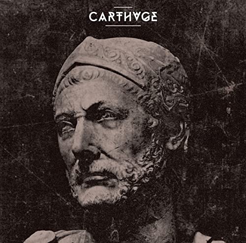Close-up of a weathered stone bust with "CARTHUGE" text above.