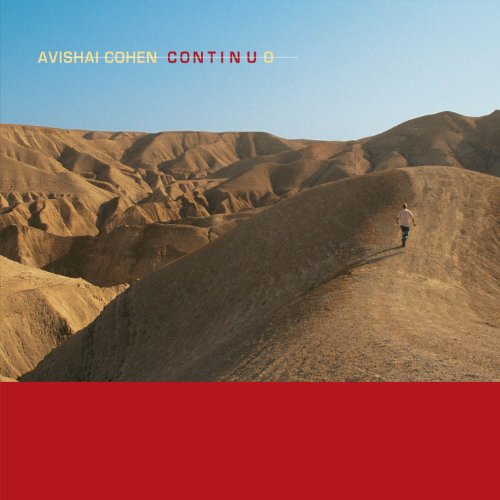 CD cover: desert landscape with a lone figure walking on a ridge.