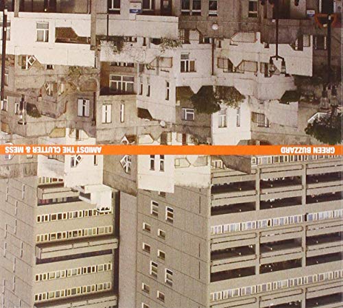 Gray concrete housing complex with orange text: "Green Buzzard - Amidst The Clutter & Mess.